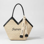 Beige Straw Tote Bag With Black Handles And Ribbon Charm – bags & wallets (view 1)