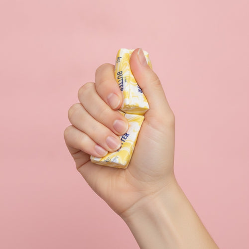 4oz Salted Butter Sticks Yellow Swirl Design - squeeze in hand